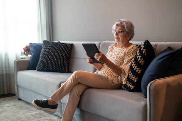 istock Senior Woman at home using a digital tablet 1415491243