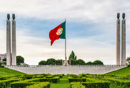 Edward VII park (Parque Eduardo VII) in Lisbon, a green space in the center of the city - Flag of Portugal waving in the center of the columns - Travel concept