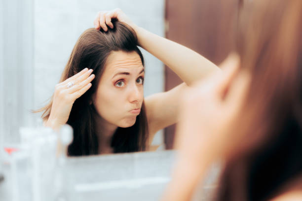 femme vieillissante stressée vérifiant les cheveux gris - cheveux blancs photos et images de collection