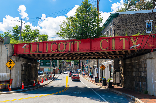 Ellicott City, Maryland - August 7, 2022: Marked by a red painted railroad bridge, the Ellicott City Historic District lies in the valleys of the Tiber and Patapsco rivers. Many of its buildings were constructed in the 1800s.