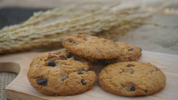 istock Chocolate cookies with on wooden cutting board and on burlap surface 1415495822