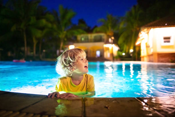 istock Kids in swimming pool at night 1415496801