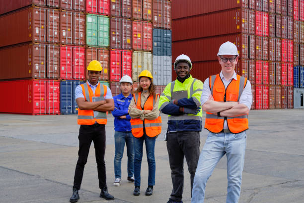 Group of workers teamwork at logistics dock with many stacks of containers. stock photo
