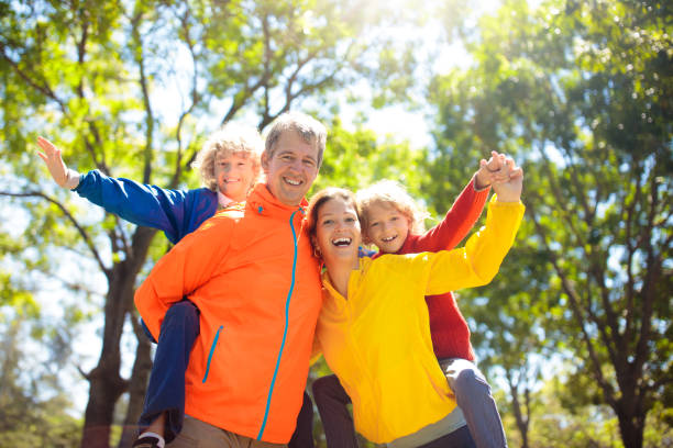 istock Family walking in autumn park. Fall fun. 1415498136