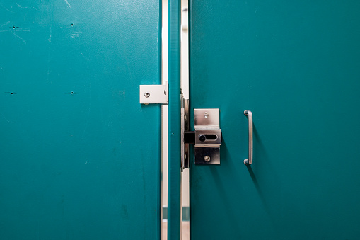 Generic metal public bathroom stall latch closed with the door gap shown. . High quality photo