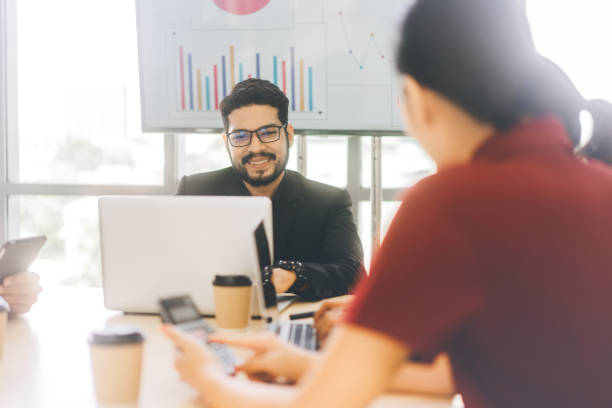 istock Executive business man with beard using laptop sitting talk about finance and profits strategy with team in meeting room 1415509583