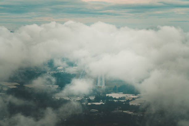 Airport Runway in Rionegro International airport that serves Medellin, Colombia. seen from a commercial airplane between clouds and low fog in the morning.