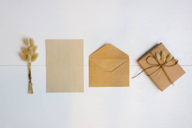 istock Brown gift box, flowers, brown paper and envelop over the white background. 1415515338