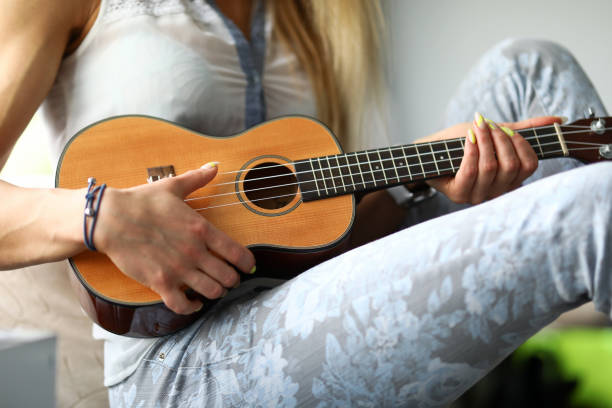 istock Girl playing on the ukulele at home 1415515349