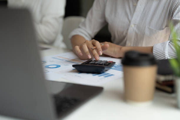 istock Close up accountant banker or bookkeeper making calculations with calculator 1415523980