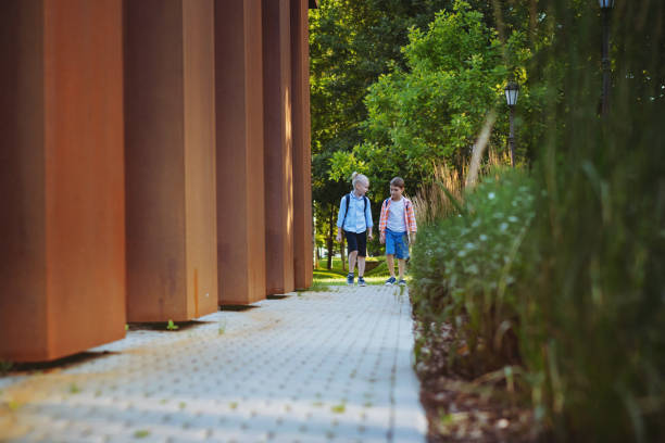 istock children walking to school. Begining of academic year 1415526338