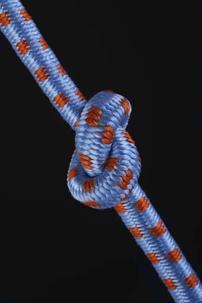 istock Colored ropes tied in a knot on a black background 1415527296