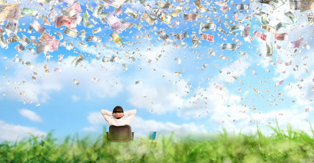 Businessman and large group of various global paper currencies falling from sky stock photo
