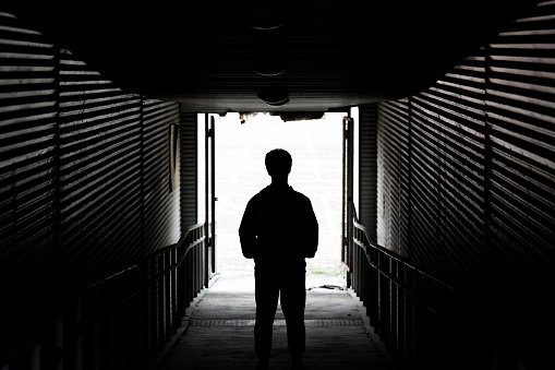 Rear view of businessman standing in a dark tunnel