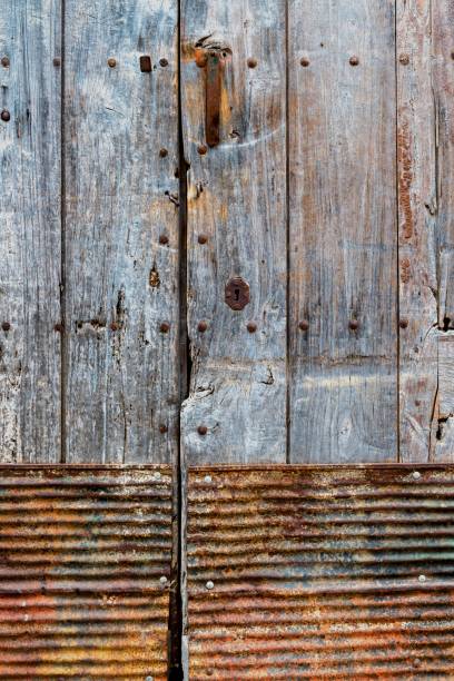 istock Rustic wooden door and rusted metal handle. Textured background 1415528287