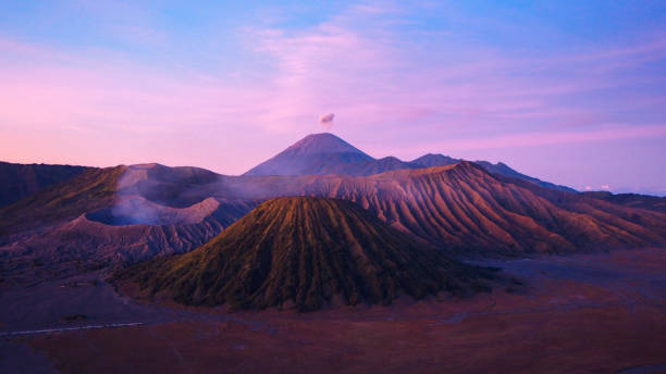 Mount Bromo at sunset Sunrise on Mount Bromo with Mount Semeru smoking in the background bromo tengger semeru national park stock pictures, royalty-free photos & images