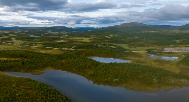 istock Sunset over lakes surrounded by green forest 1415531778