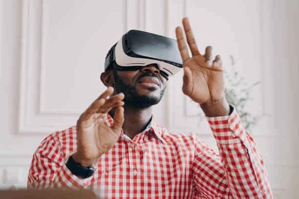 istock Black man in VR glasses experiencing 3D technology of augmented reality 1415531889