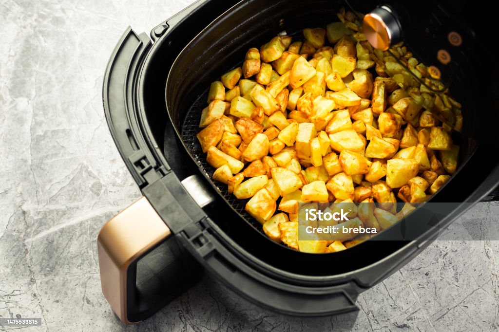 Homemade baked potatoes made in air fryer, healthy way to cook deep-fried food Air Fryer Stock Photo