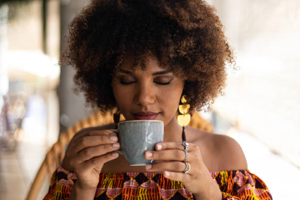 istock Young African woman smelling coffee cup 1415533831