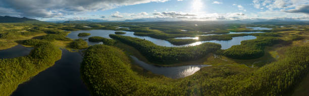 istock Sunset over lakes surrounded by green forest 1415535413