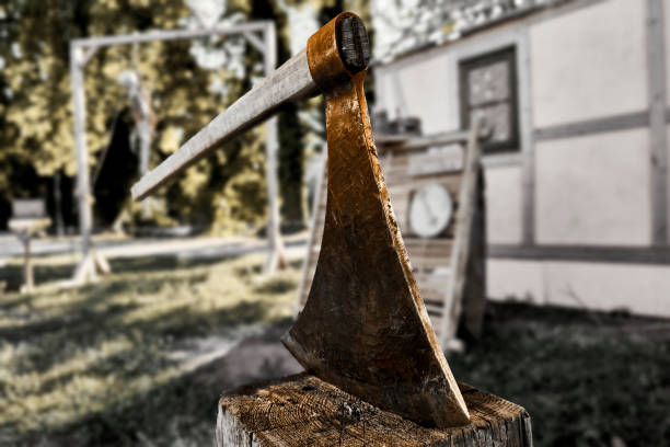 medieval executioner's axe used to strike the head of condemned to death is stuck in a raw block of wood, selective focus - metal rusty rust steel imagens e fotografias de stock