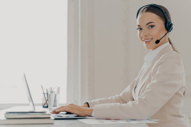 istock Smiling call center agent in headset consulting client 1415537663