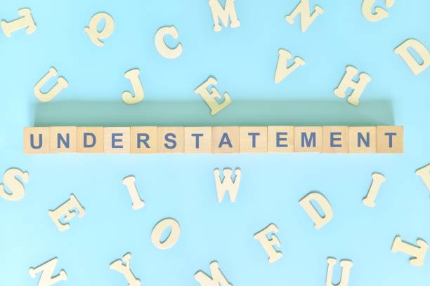 istock Understatement figure of speech figurative language concept in English grammar class lesson. Wooden blocks typography flat lay in blue background. 1415538470