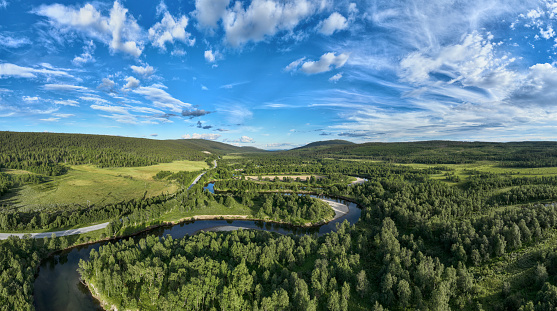 The river of Ljusnan runs like a snake through deep green forest and meadows. Along the many curves of the river there are sand beaches. Seen from above in the village of Bruksvallarna, Harjedalen, Sweden.