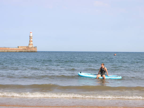 паддлбординг в море в рокер сандерленд - sunderland стоковые фото и изображения