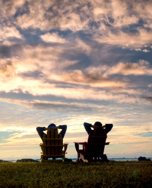 Friendship and outdoor enjoyment concept of two woman watching sunset view stock photo