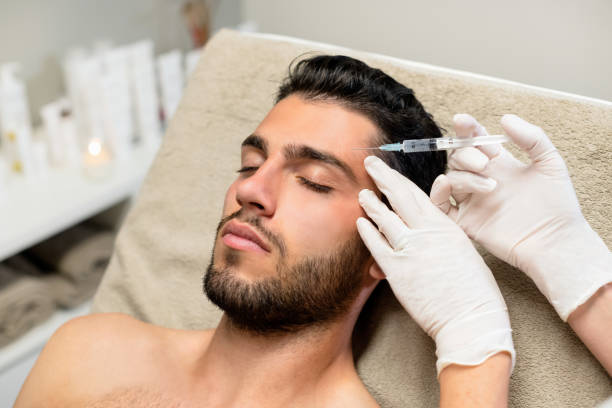 Young man receiving botox injection stock photo