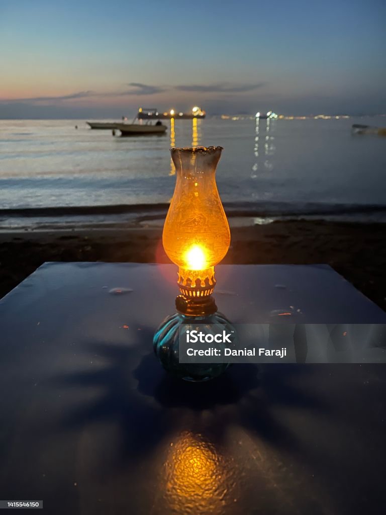 Beautiful coastal night It is very romantic to spend time with oil torch near the sea and become relax in contrast of the ancient and modernist era. Beach Stock Photo