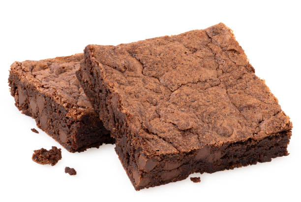 istock Two chocolate brownies with chocolate chips next to crumbs isolated on white. 1415546458