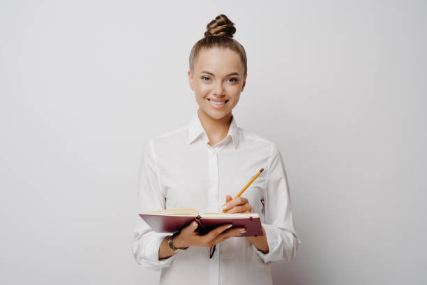 istock Business professional in white shirt writing down ideas in note book 1415547954