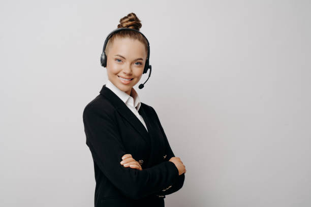 istock Friendly business woman in headset in dark suit ready for web conference 1415547991