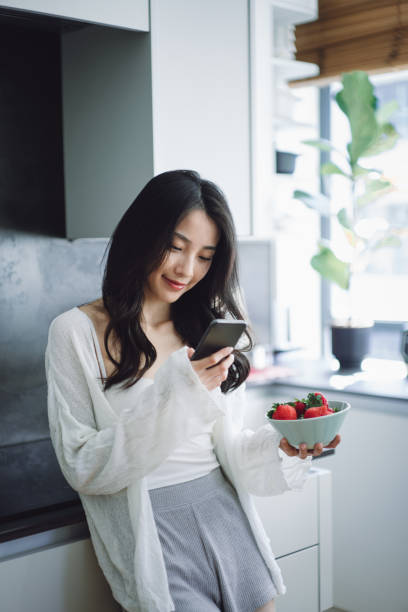 istock Asian beautiful woman using smartphone at home 1415549326