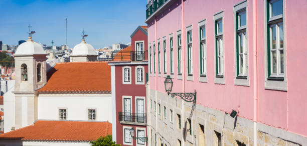 bunte häuser und eine weiße kirche in lissabon - pink buildings stock-fotos und bilder