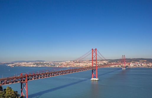 Historic red suspension bridge over the Tejo river in Lisbon