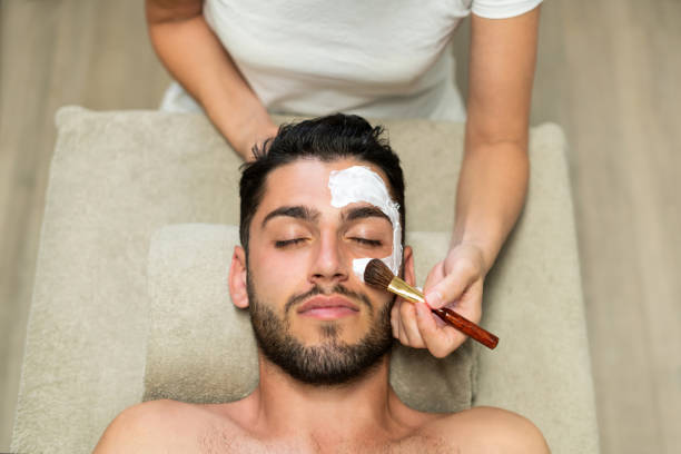 Beautician doing facial skin treatment to customer stock photo