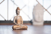 istock Figure of a buddha with joined hands in ceremony room. 1415554693