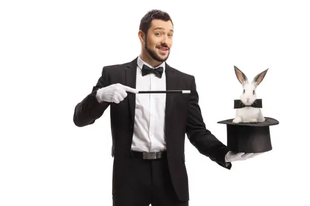 Magician performing a trick with a hat and a rabbit isolated on white background