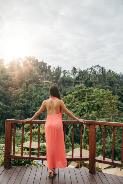 istock Woman standing by a railing at luxury resort 1415557734