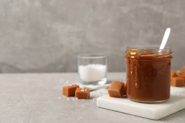 istock Tasty salted caramel on light grey table, space for text 1415559465