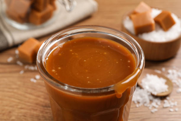 istock Tasty salted caramel in glass on table, closeup 1415559492