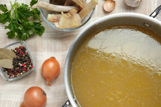 istock Delicious homemade bone broth and ingredients on table, flat lay 1415560060