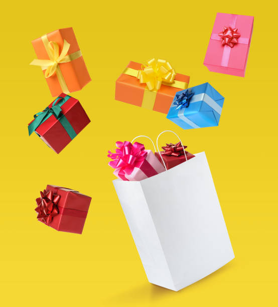 istock Many different gift boxes falling into paper shopping bag on yellow background 1415560956