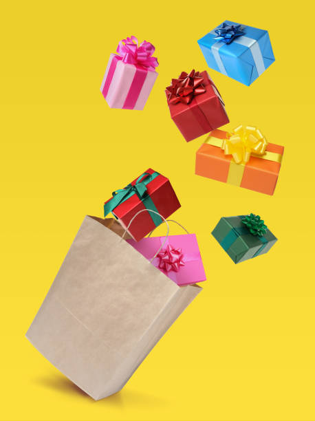 istock Many different gift boxes falling into paper shopping bag on yellow background 1415561228