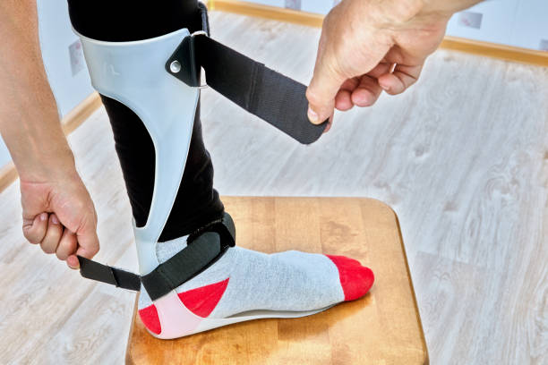 istock Ankle foot orthosis brace is fixed on leg with velcro straps. 1415561508
