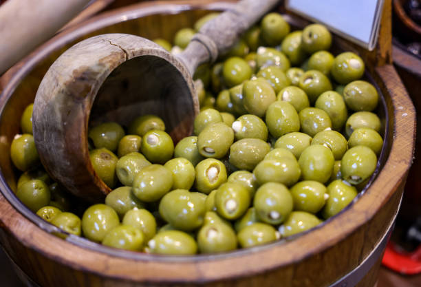 Stuffed green olives in an old wooden bowl stock photo